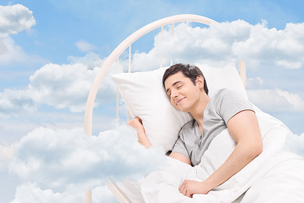 Man sleeping on a bed in the clouds