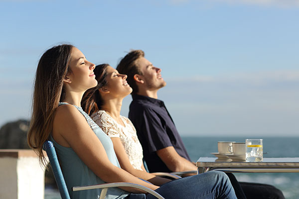 Group of friends breathing fresh air in a restaurant on the beac